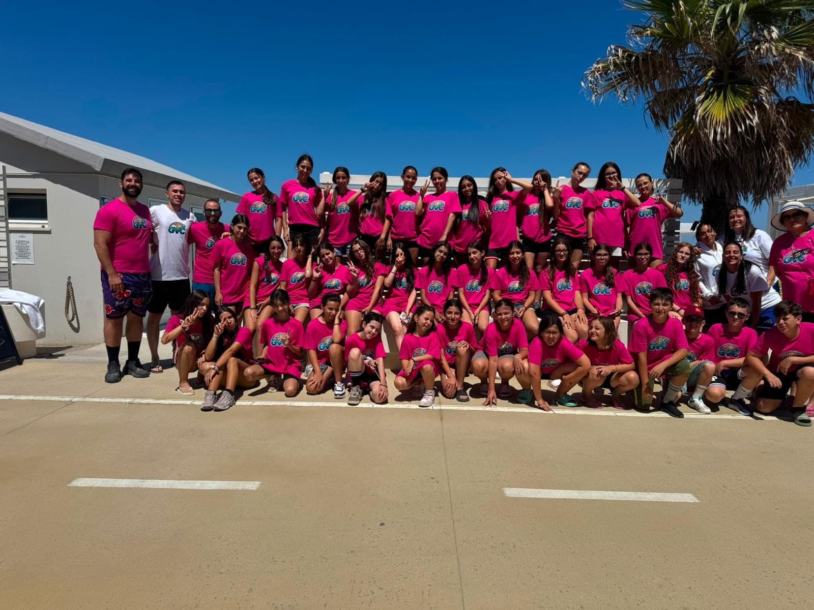 Foto di gruppo di GiocaVolley Academy: atlete e staff con la maglia rosa GVA